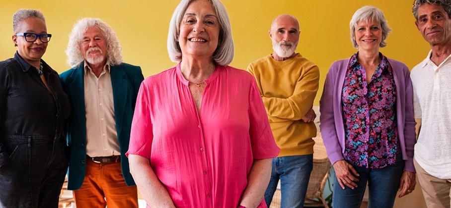 Group of happy seniors standing in a row